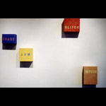 Installation detail 4 colour text paintings on cubes, left to right words 'chaos', 'jam', 'glitch', 'impede'